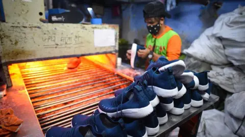 Getty Images Shoes staked up before going into a machine