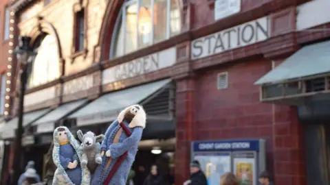 PA Media Miniature knitted figurines of Mary, Joseph and a donkey outside Covent Garden Station.